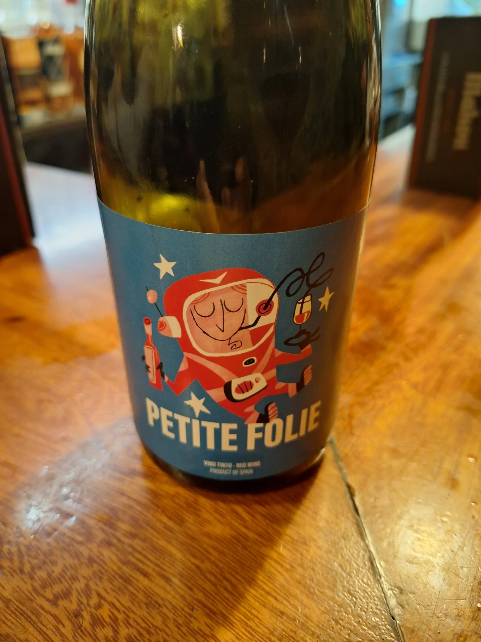 De fles Petite Folie, met een astronaut op het etiket