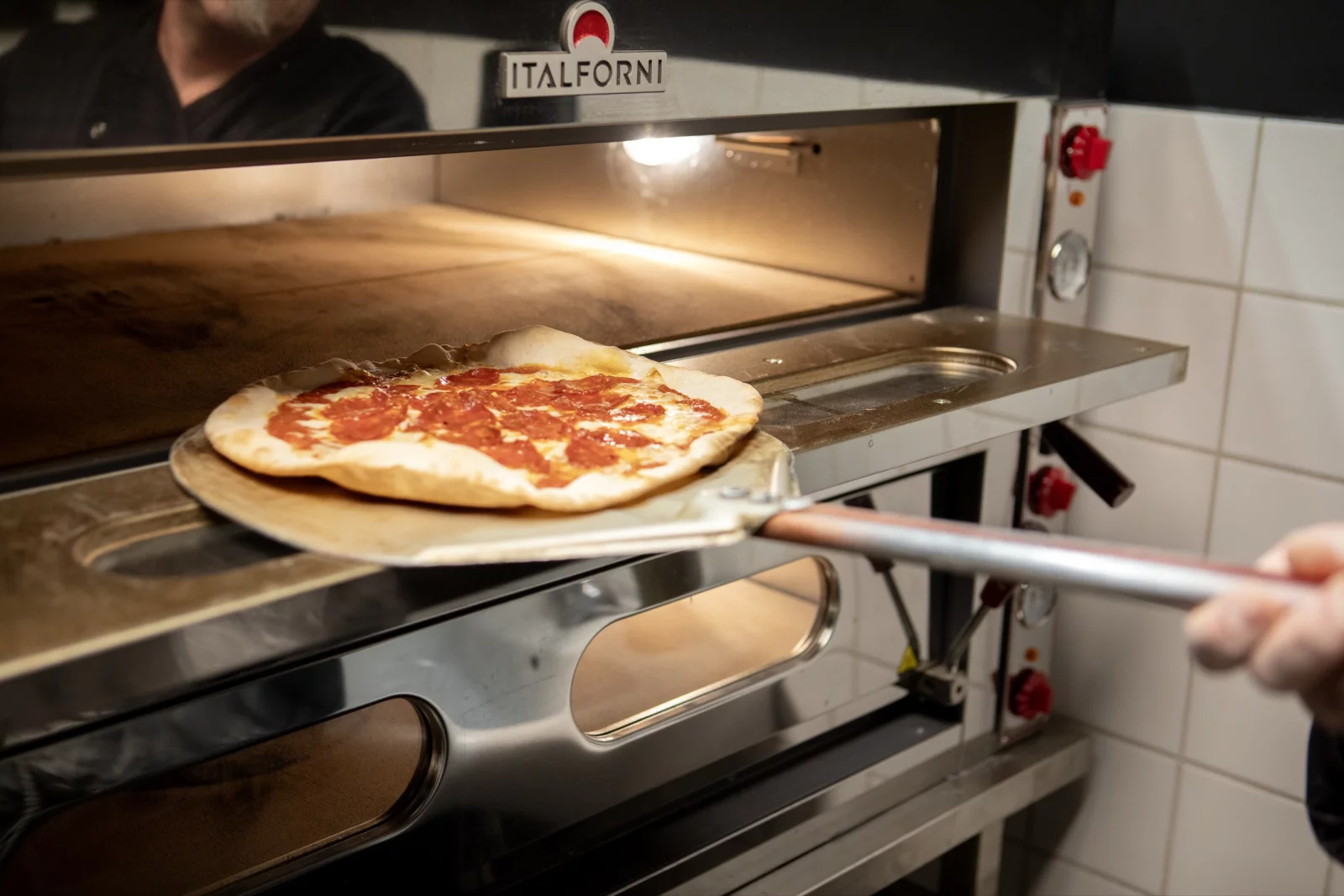 A pizza going into the oven on a peel at Il Padrino