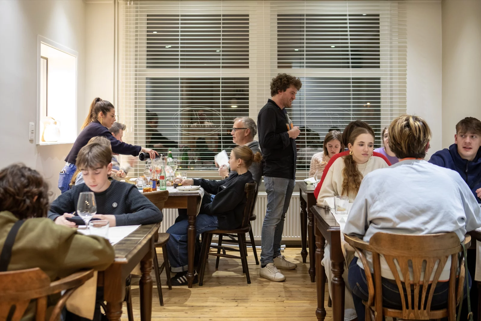A packed dining room at Il Padrino, with guests at the tables and staff in between