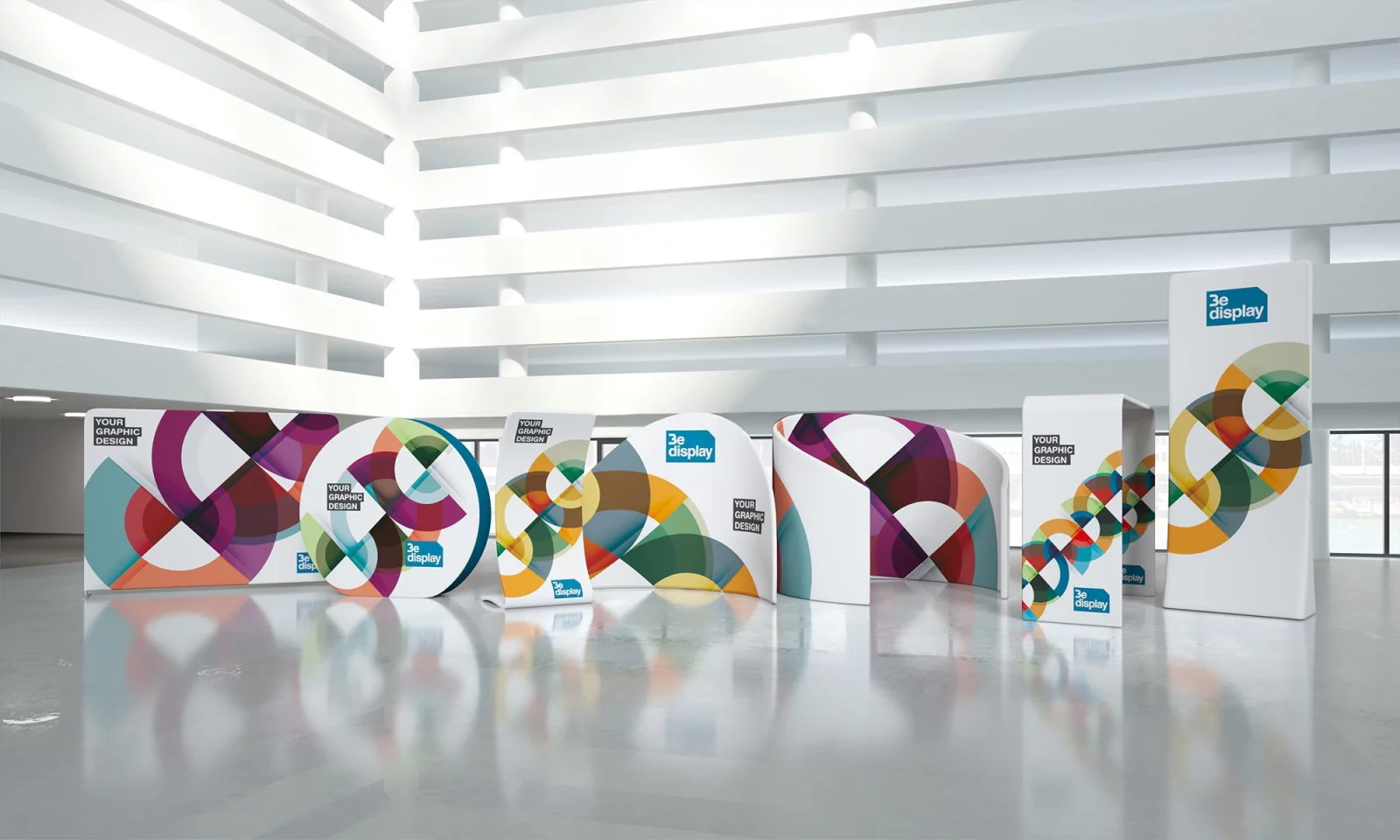 A row of textile displays in arches, waves and towers in a bright hall, with colourful graphic fabrics
