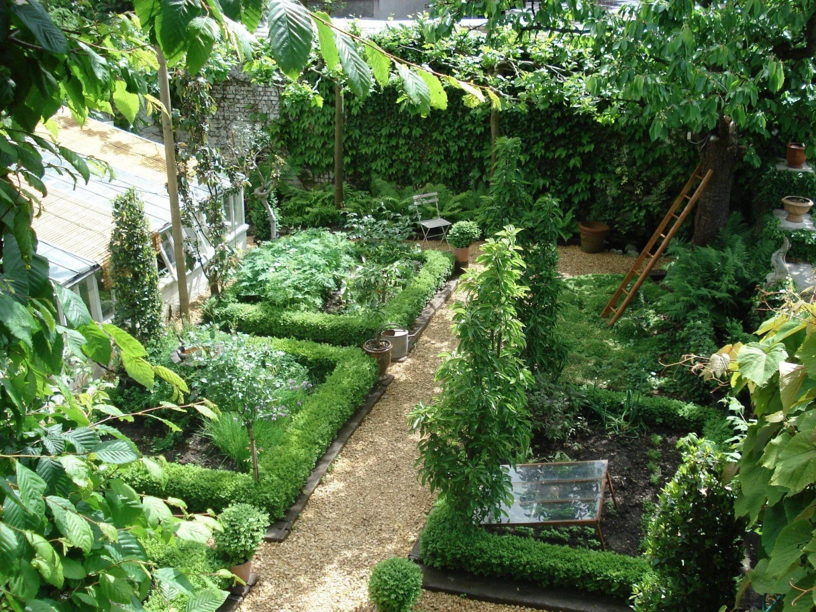 The town garden behind the restaurant, with box hedging, gravel paths and a ladder against a tree